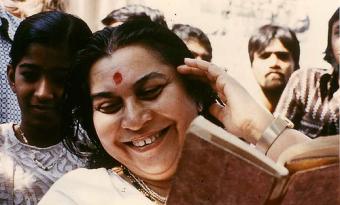 Shri Mataji smiling while reading a book in India